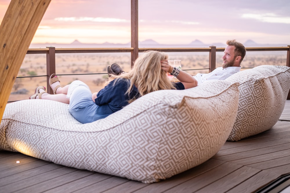 a man and a woman sitting on bean bags on a deck