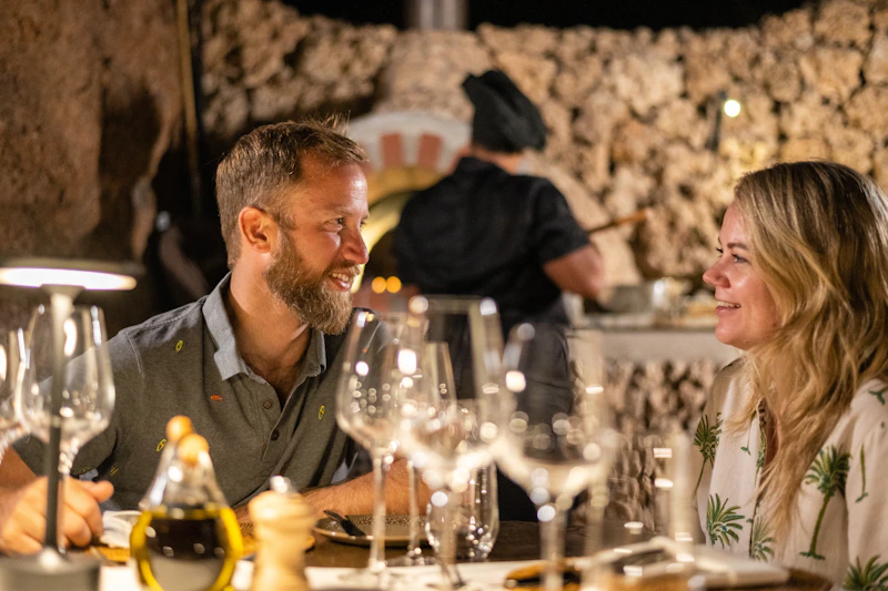 a man and a woman sitting at a table with wine glasses