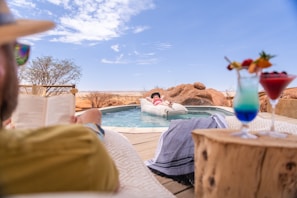 a man reading a book next to a pool