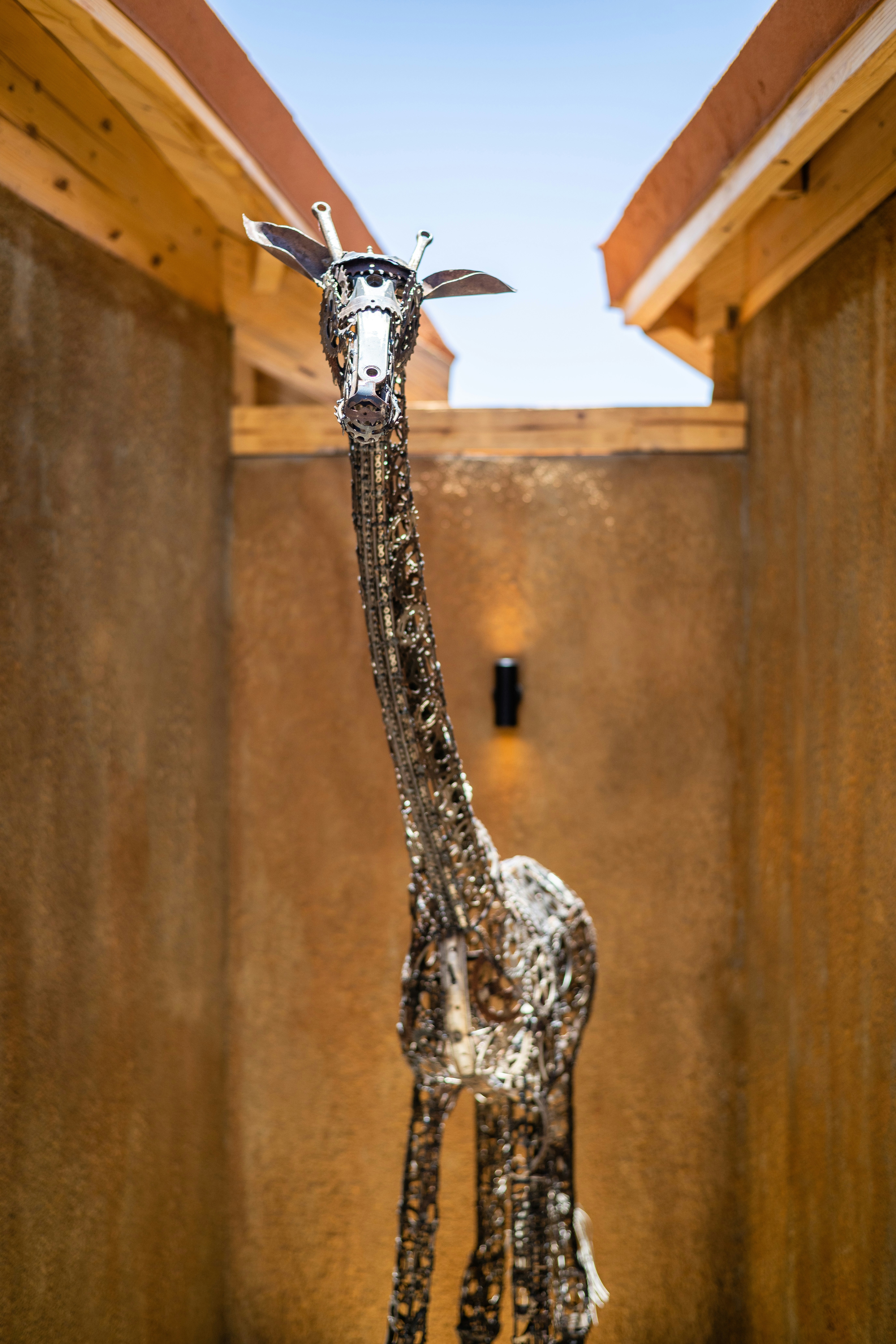a statue of a giraffe in a wooden enclosure