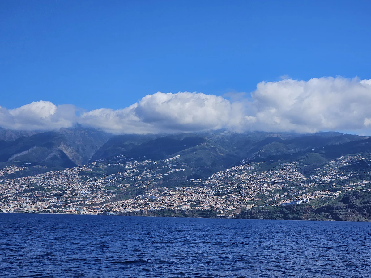 Steep green peaks rising above a wide stretch of sea
