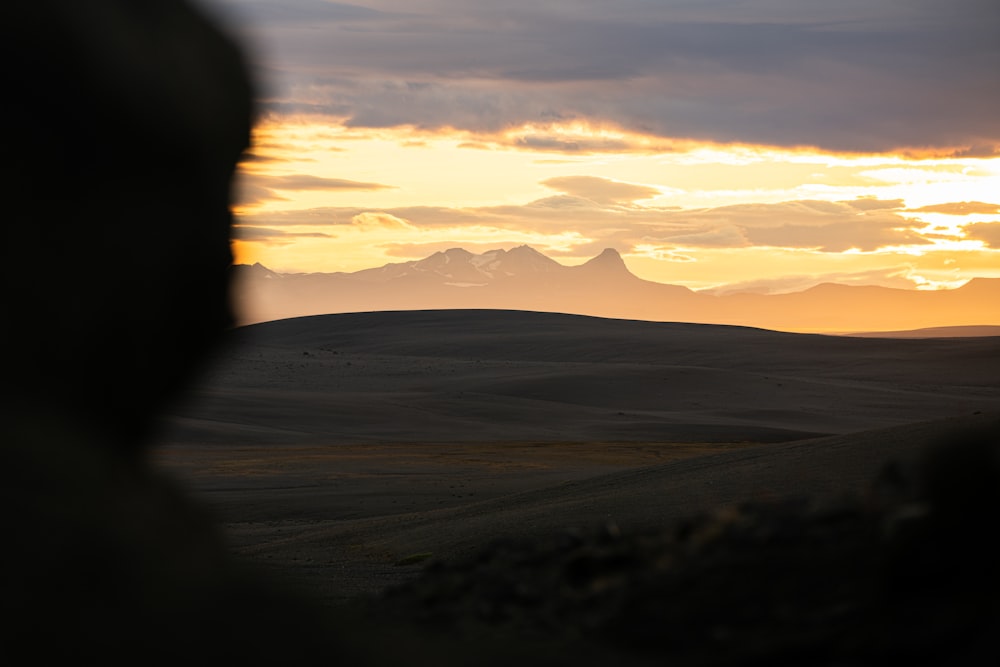 a view of a mountain range with a sunset in the background