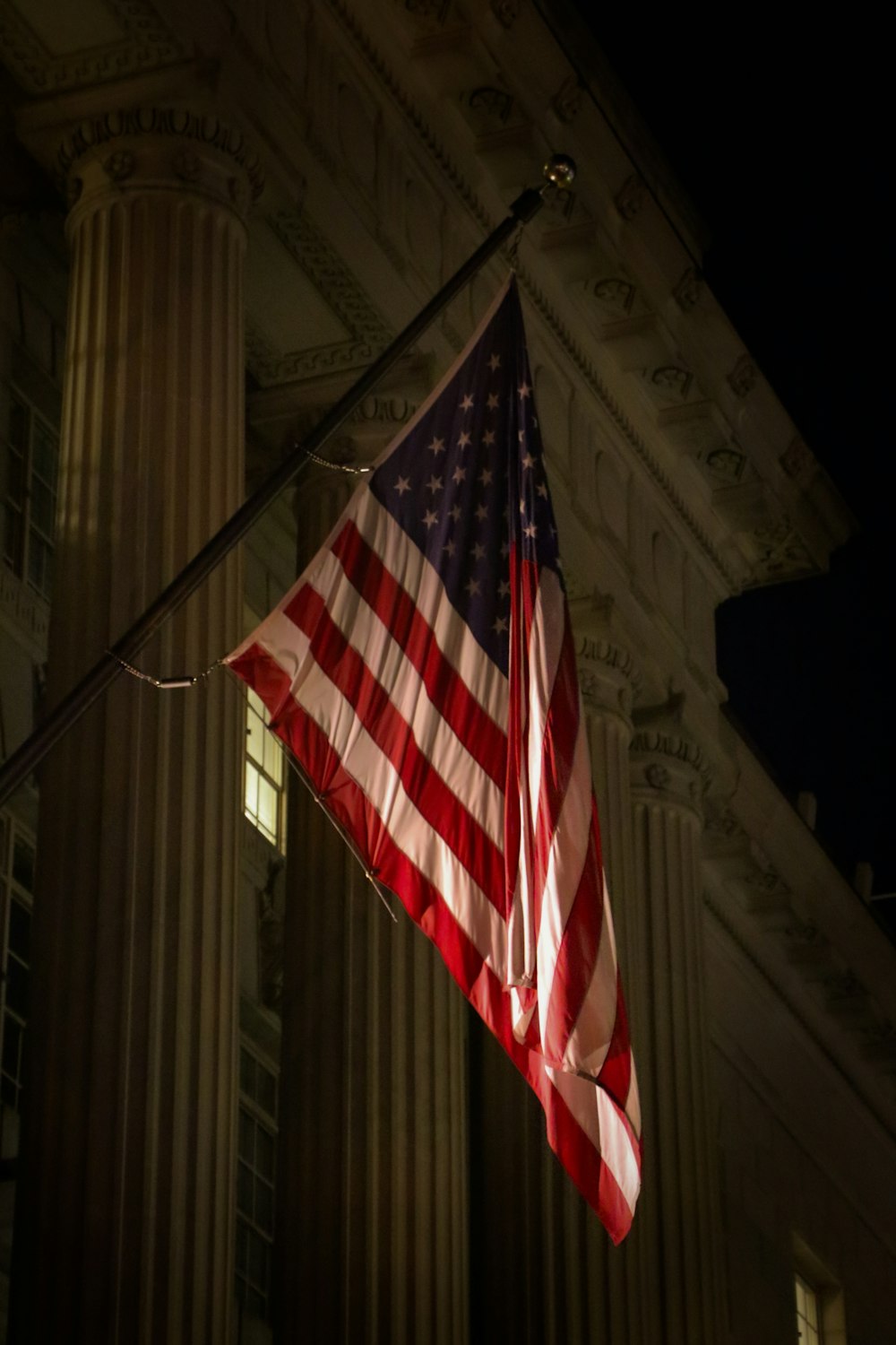 an american flag hanging from a pole in front of a building
