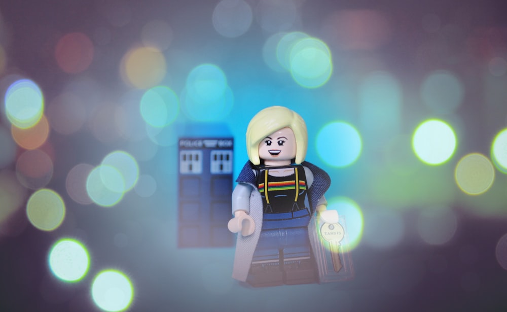 a lego figure is standing in front of a blurry background