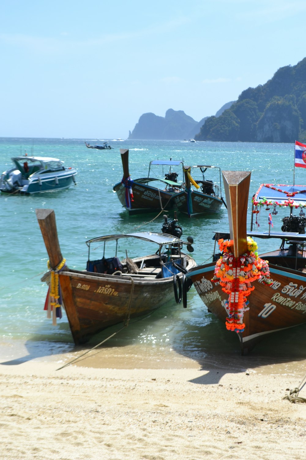 a group of boats sitting on top of a sandy beach