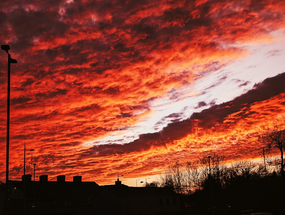 un cielo rojo con nubes y una farola