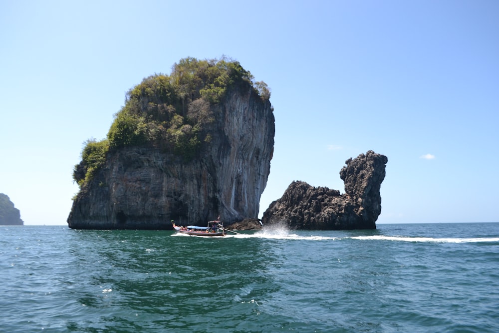 a boat in the water near a rock formation