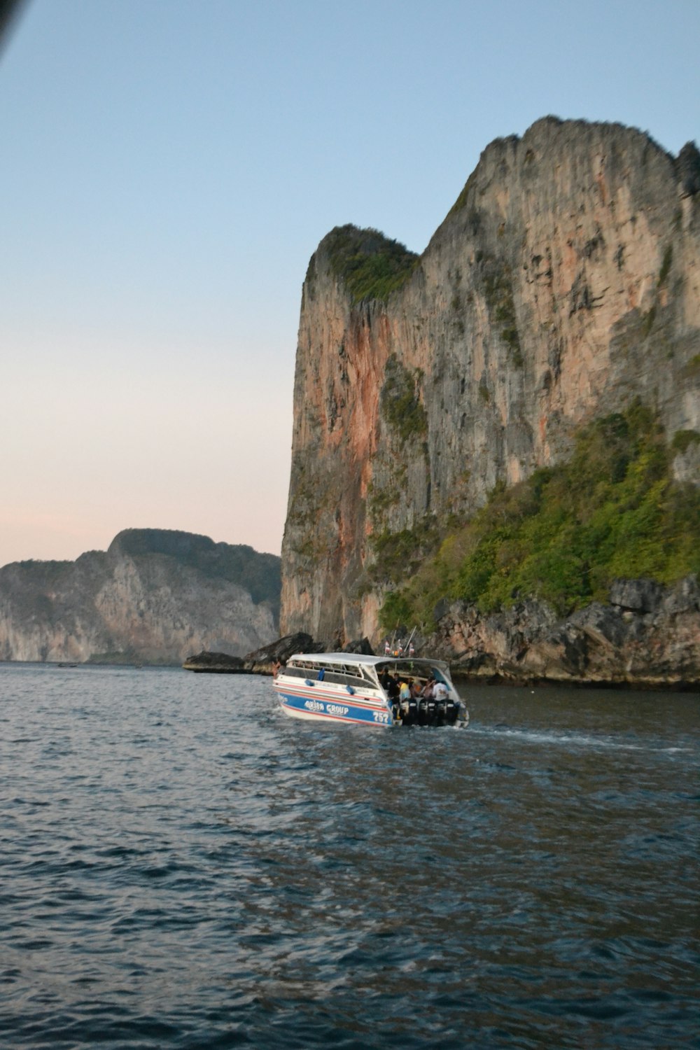 a boat is traveling through the water near a mountain