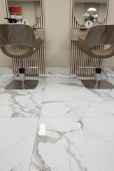 a pair of chairs sitting on top of a marble floor