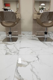 a pair of chairs sitting on top of a marble floor