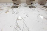 three chairs sitting on a marble floor in a room
