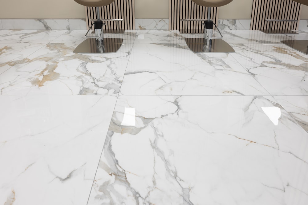 three chairs sitting on a marble floor in a room