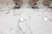 three chairs sitting on a marble floor in a room