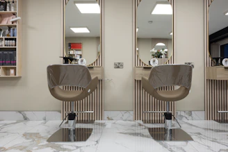 a hair salon with two mirrors and a chair
