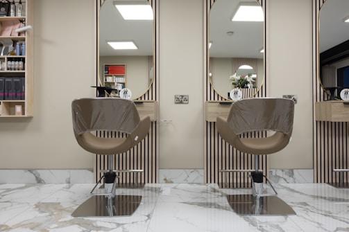 a hair salon with two mirrors and a chair