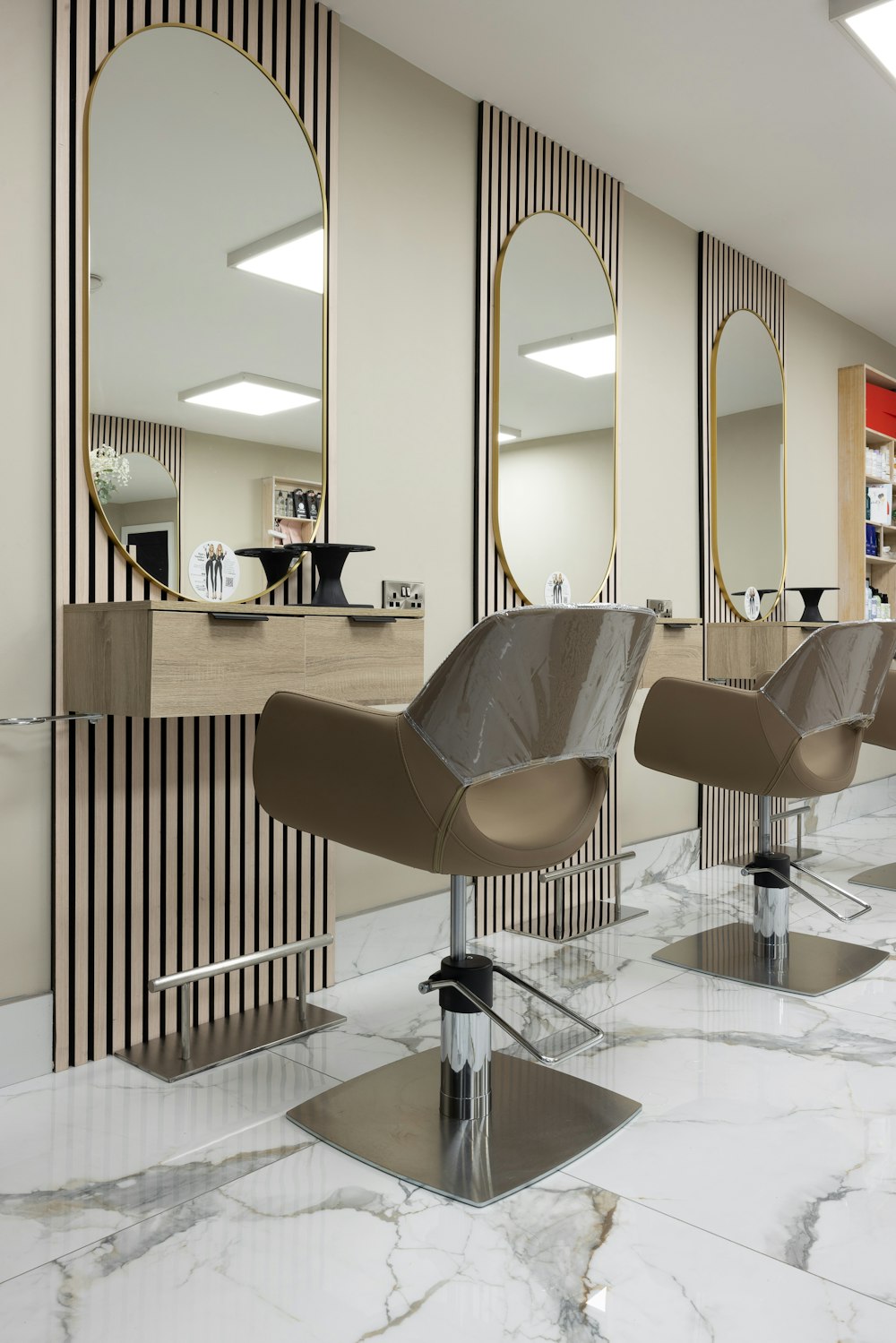 a hair salon with chairs and mirrors on the wall