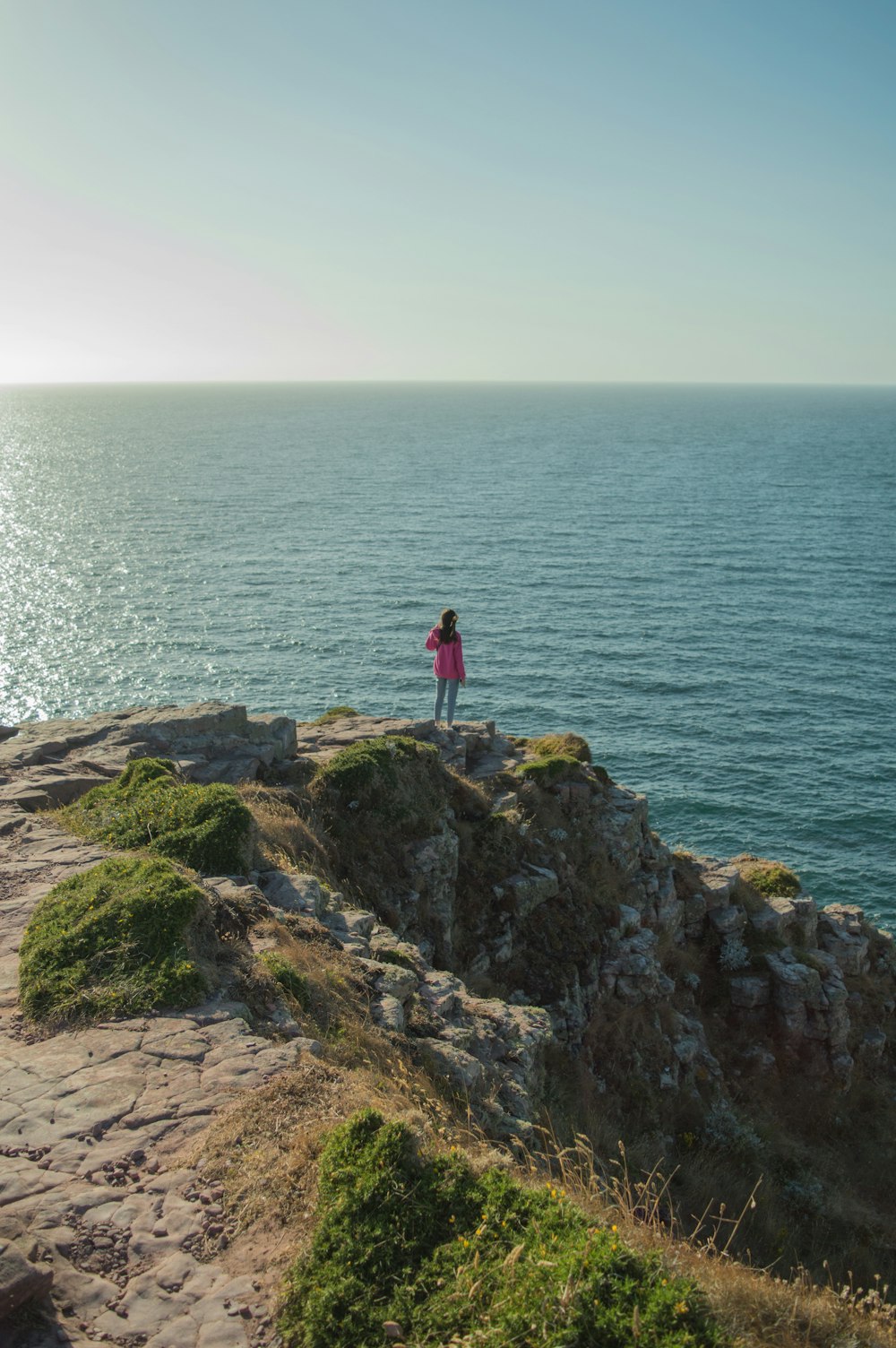 a person standing on a cliff overlooking the ocean