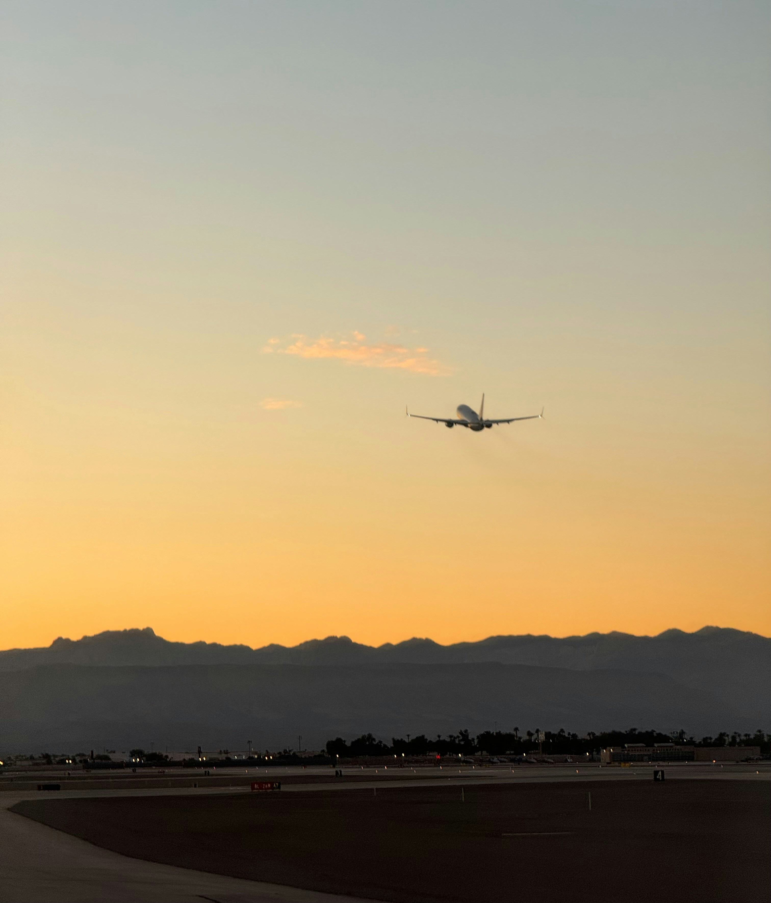 Un avión vuela en el cielo al atardecer