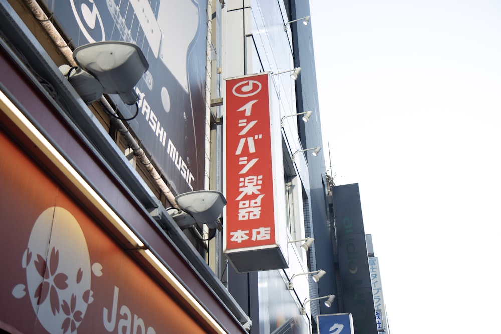 a red sign hanging from the side of a building