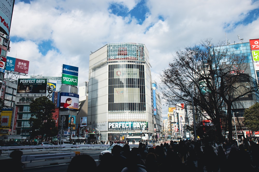 a crowd of people walking down a street next to tall buildings