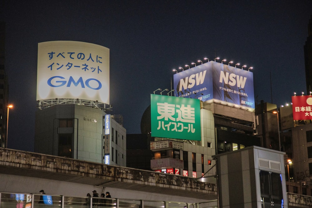 a city street at night with billboards in the background