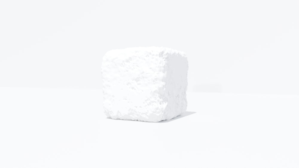 a white cube of sugar on a white surface