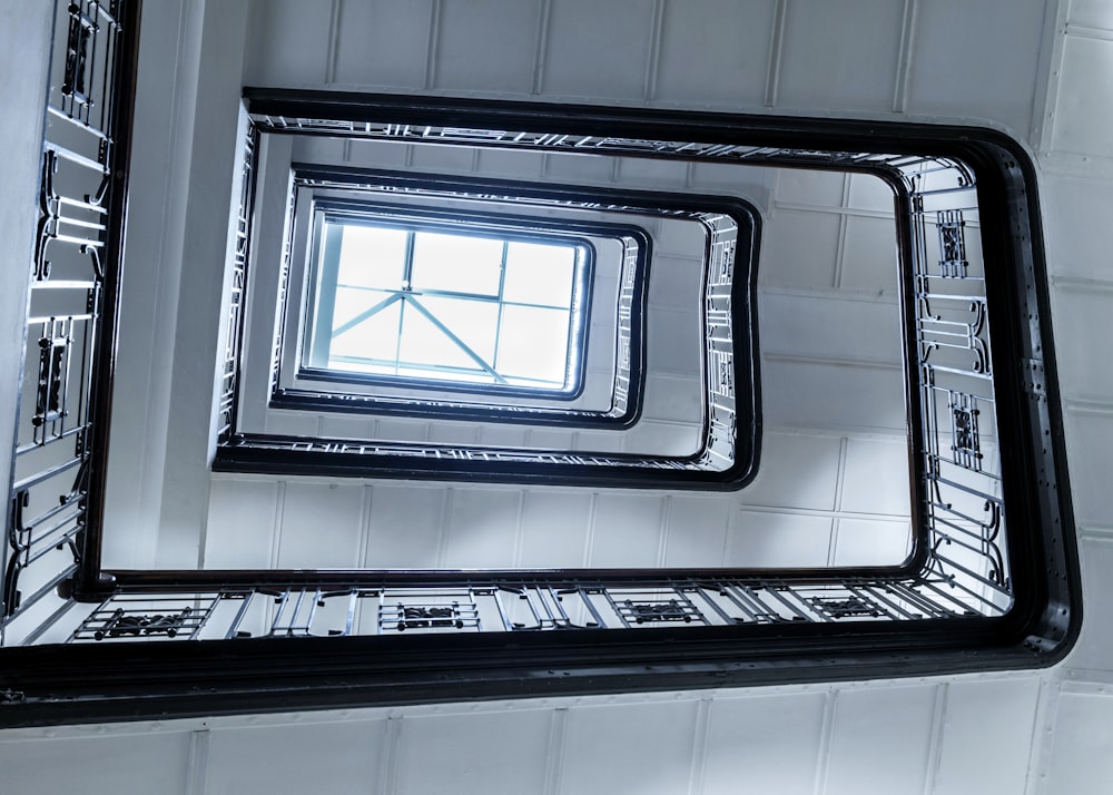 a mirror reflecting a square window in a bathroom