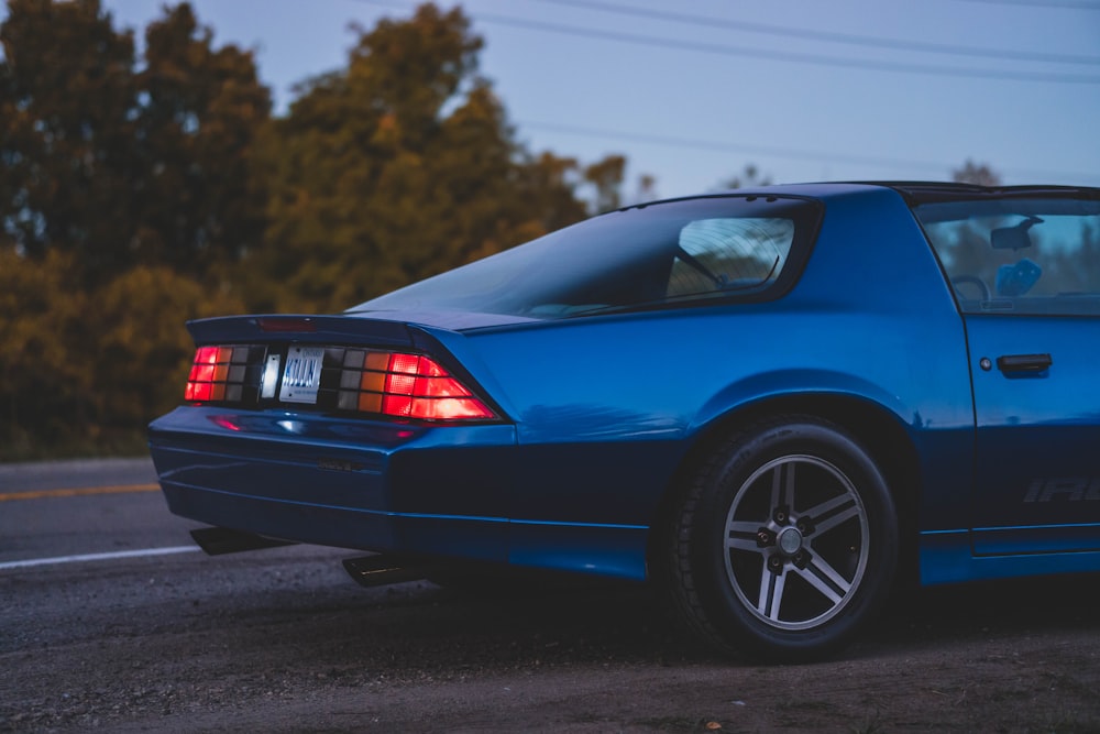 Un coche deportivo azul aparcado a un lado de la carretera