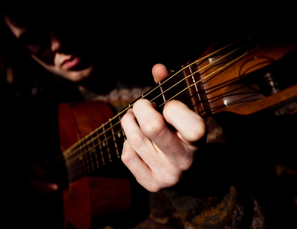 a person playing a guitar in the dark