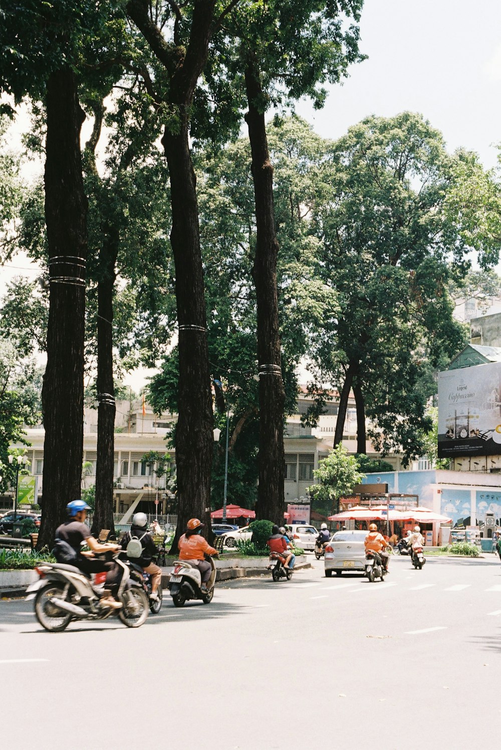 a group of people riding motorcycles down a street