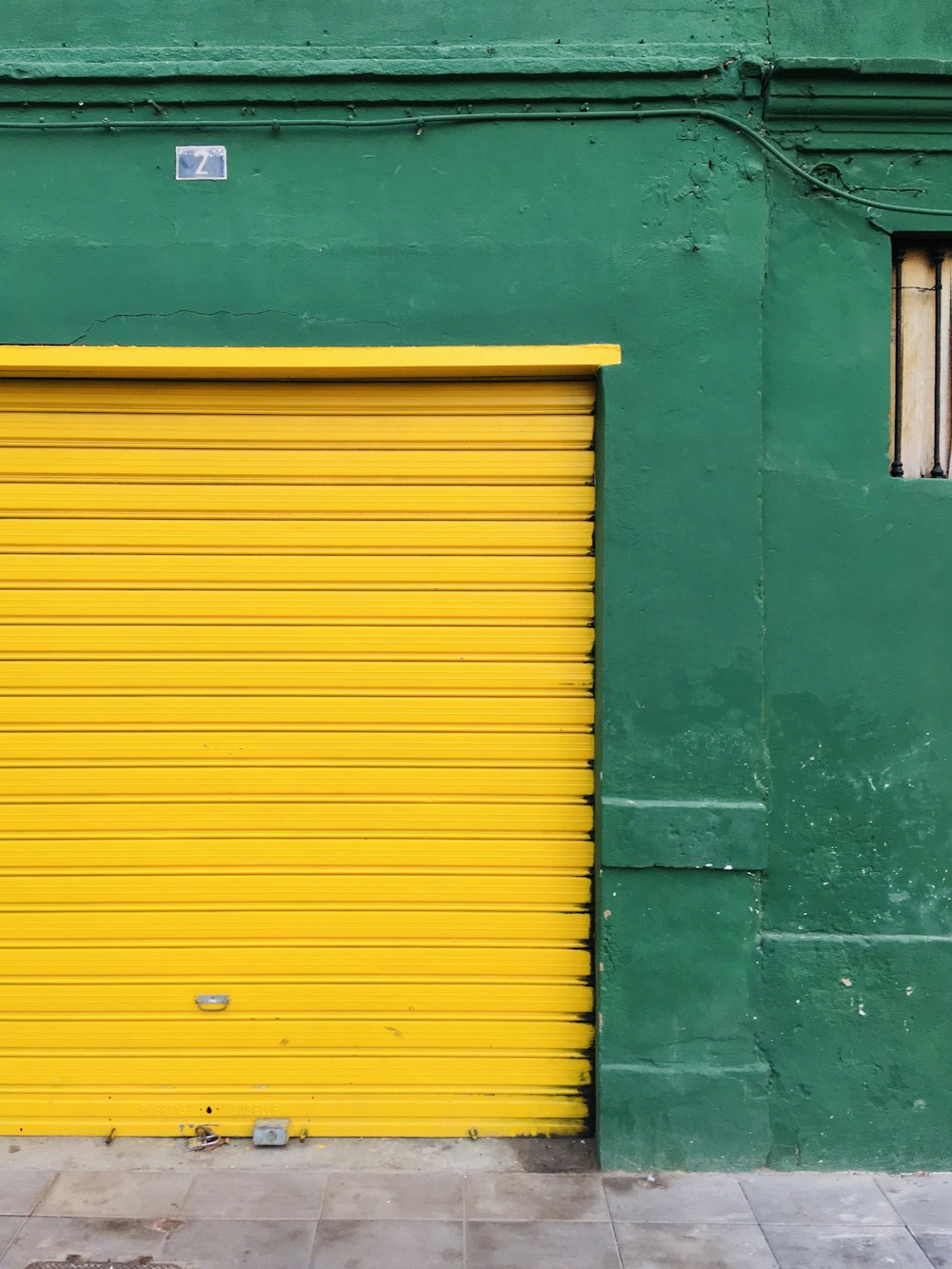 a green building with a yellow garage door