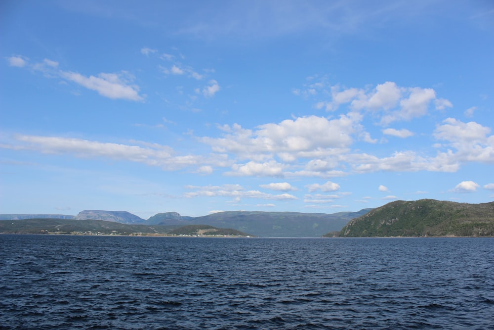 a body of water with mountains in the background