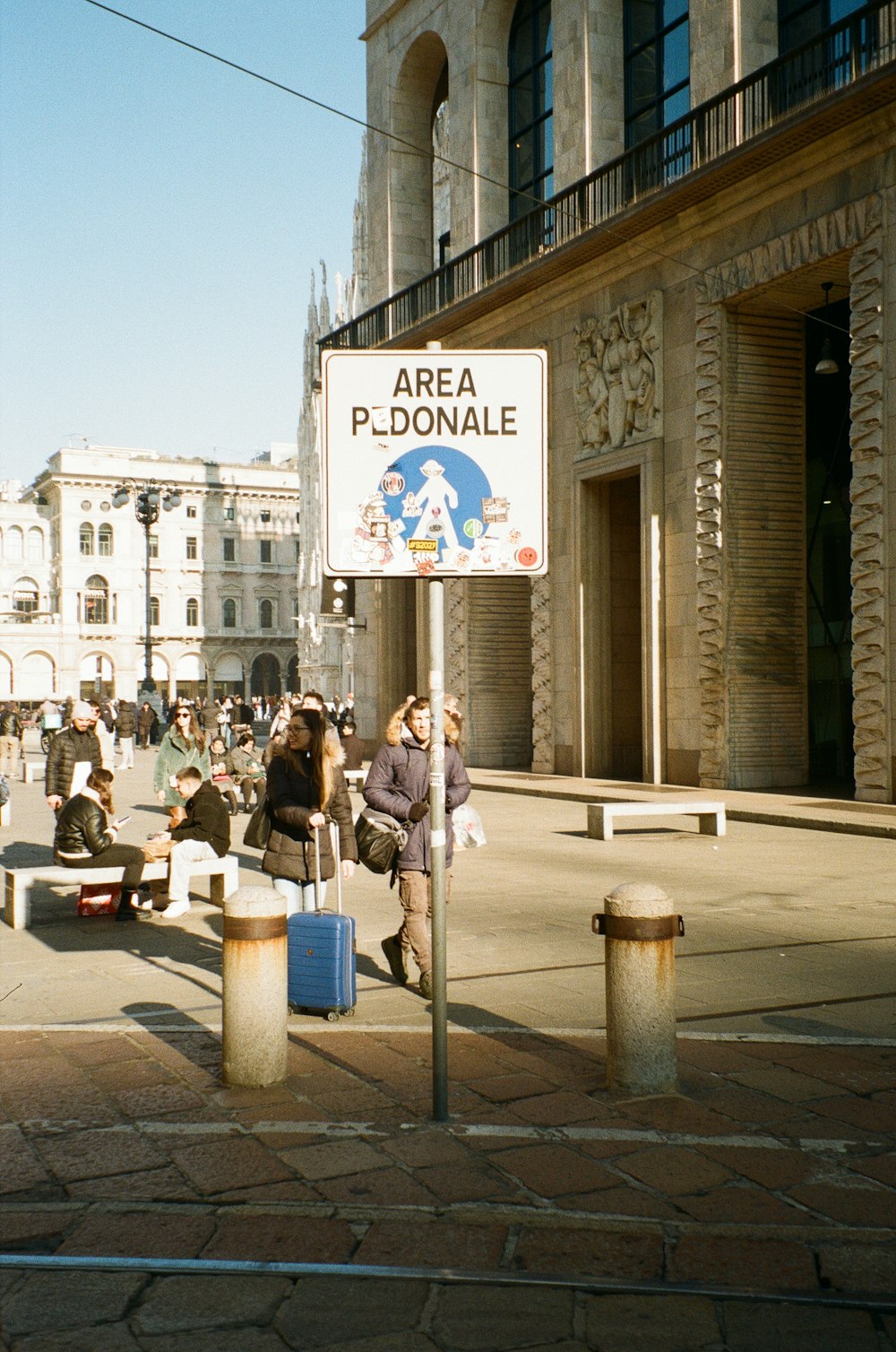 a group of people walking down a street next to a building