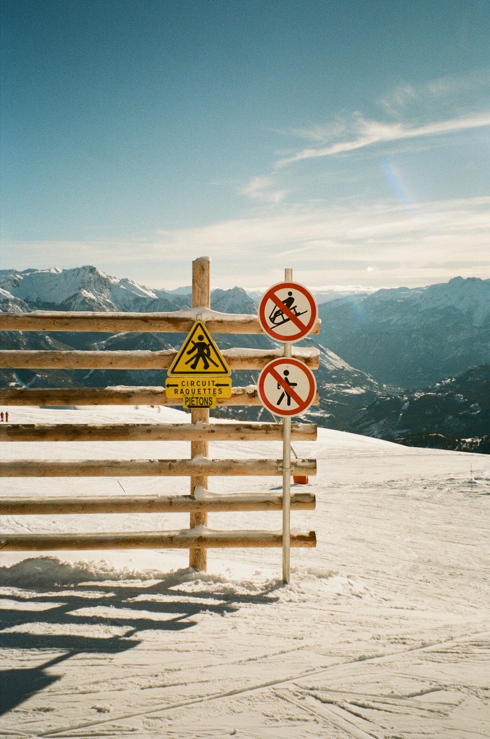 un groupe de panneaux sur une clôture en bois dans la neige
