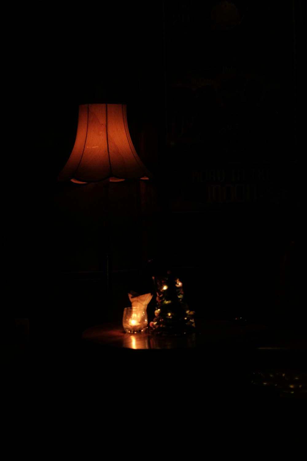 a lit candle on a table in a dark room