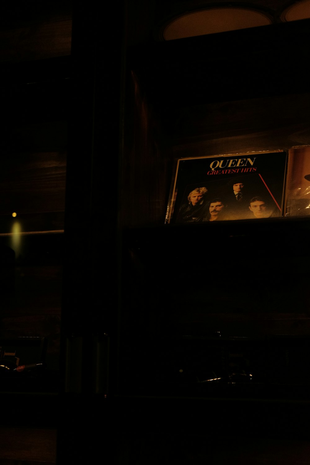 a picture of queen on a shelf in a dark room