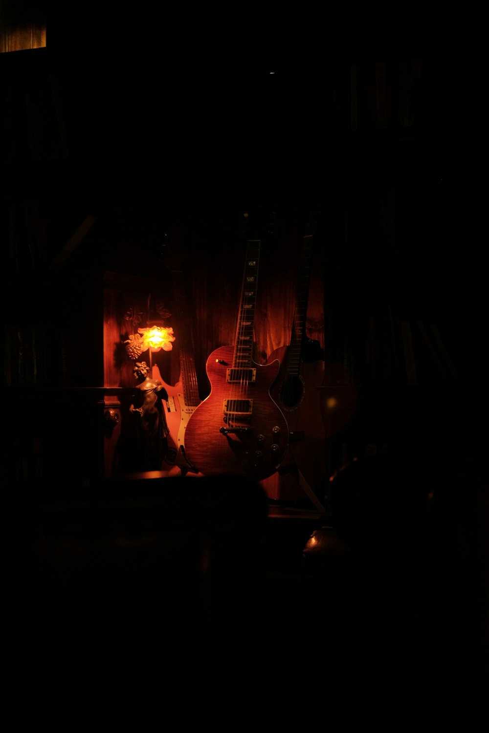 a guitar and a lamp in a dark room