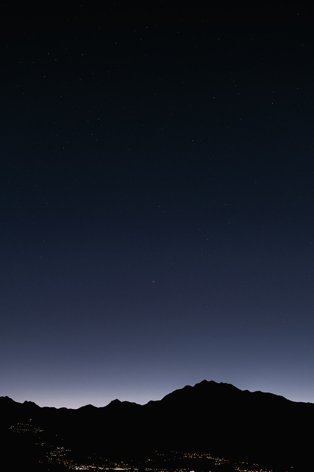 a view of the night sky with a mountain in the background