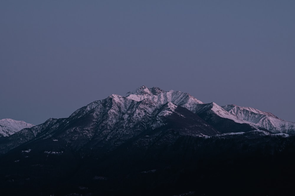 a view of a snow covered mountain at night