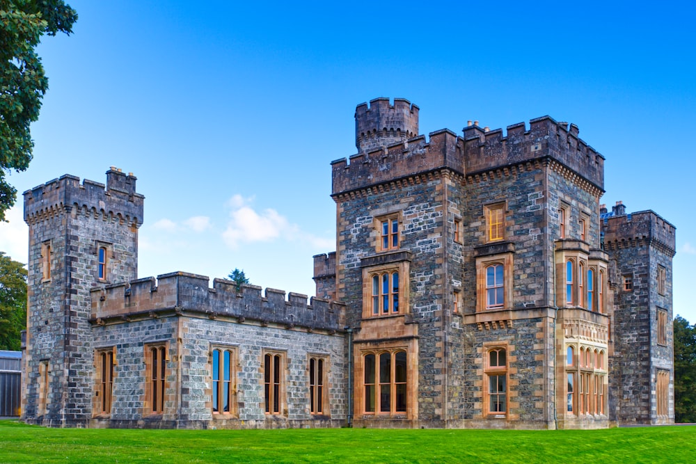 a large castle like building sitting on top of a lush green field