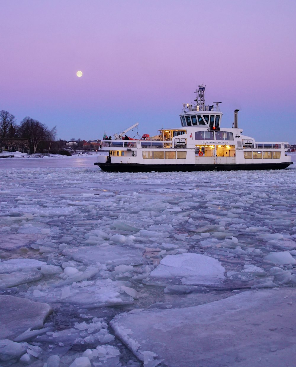 un grand bateau flottant au-dessus de l’eau couverte de glace