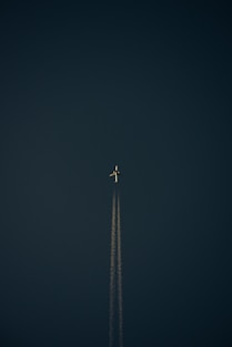 an airplane is flying in the dark sky