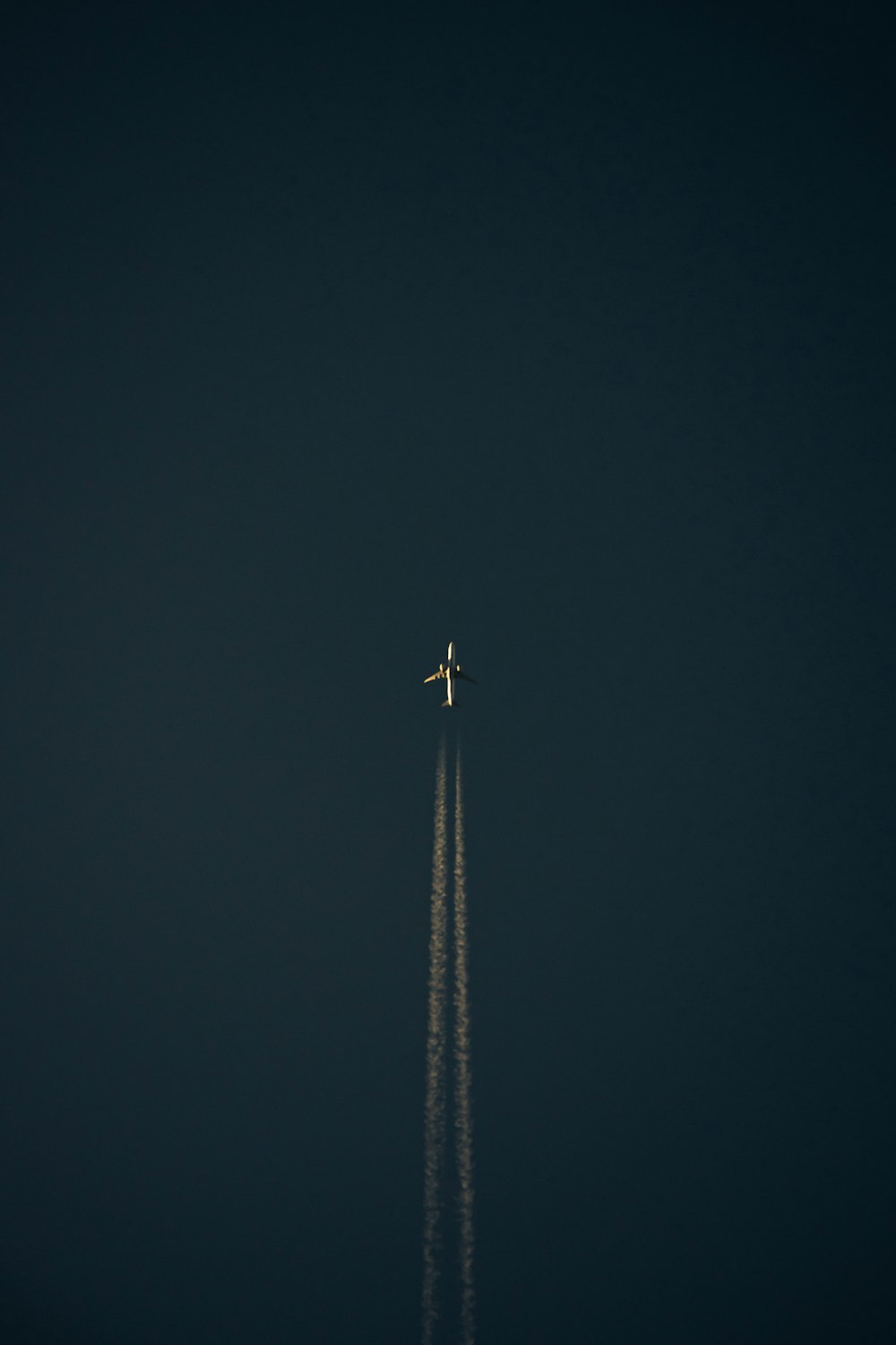 an airplane is flying in the dark sky