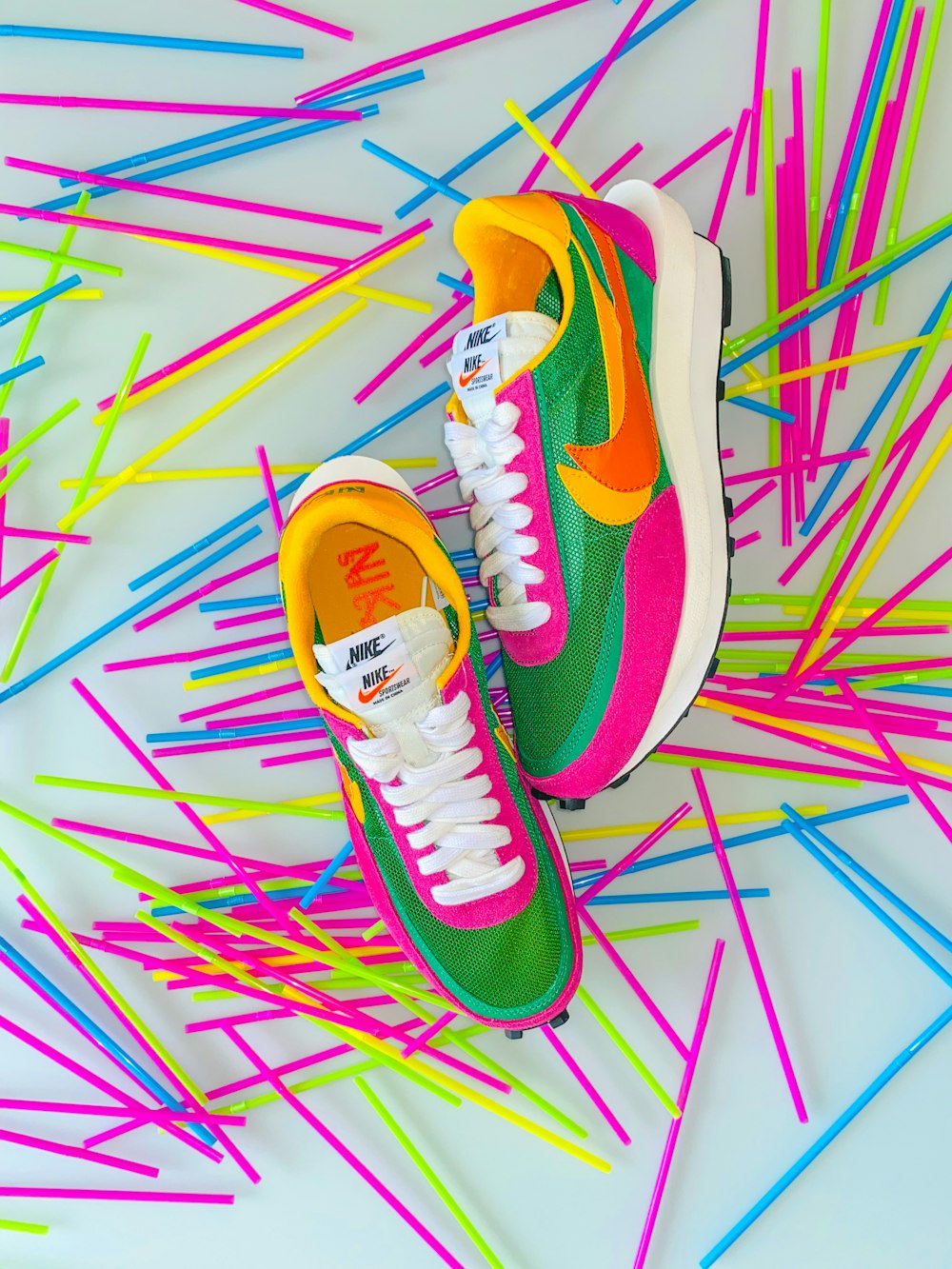 a pair of colorful sneakers sitting on top of a pile of sticks