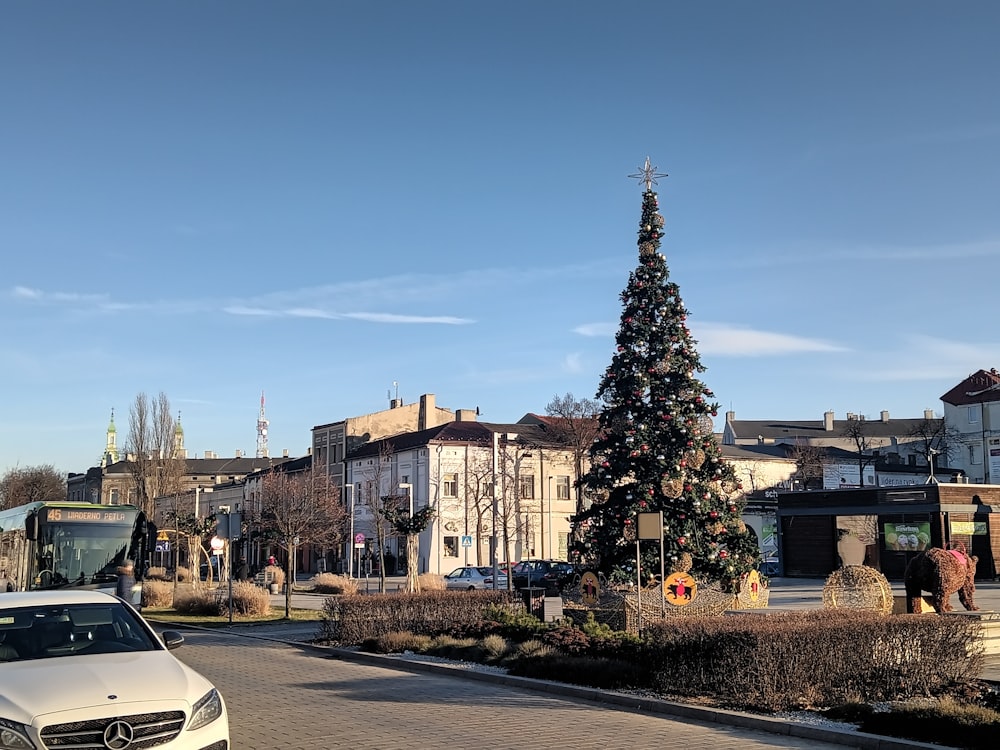 a white car parked in front of a christmas tree