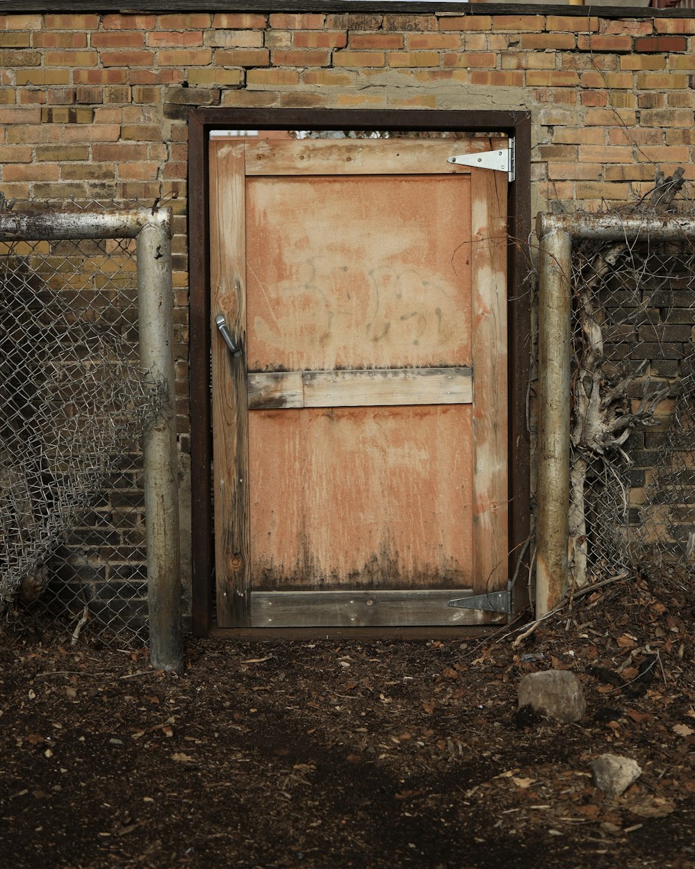 an old wooden door in front of a brick wall