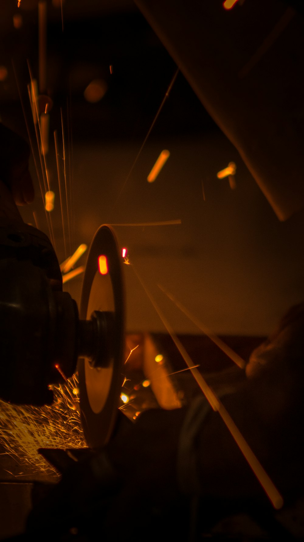 welder cutting a piece of metal with a grinder