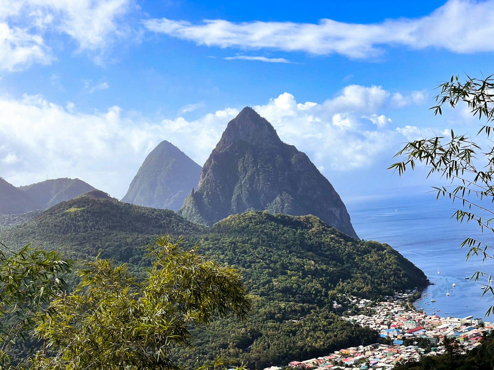St. Lucia's twin volcanic Pitons rising above green hills and a waterfront town on the Caribbean Sea