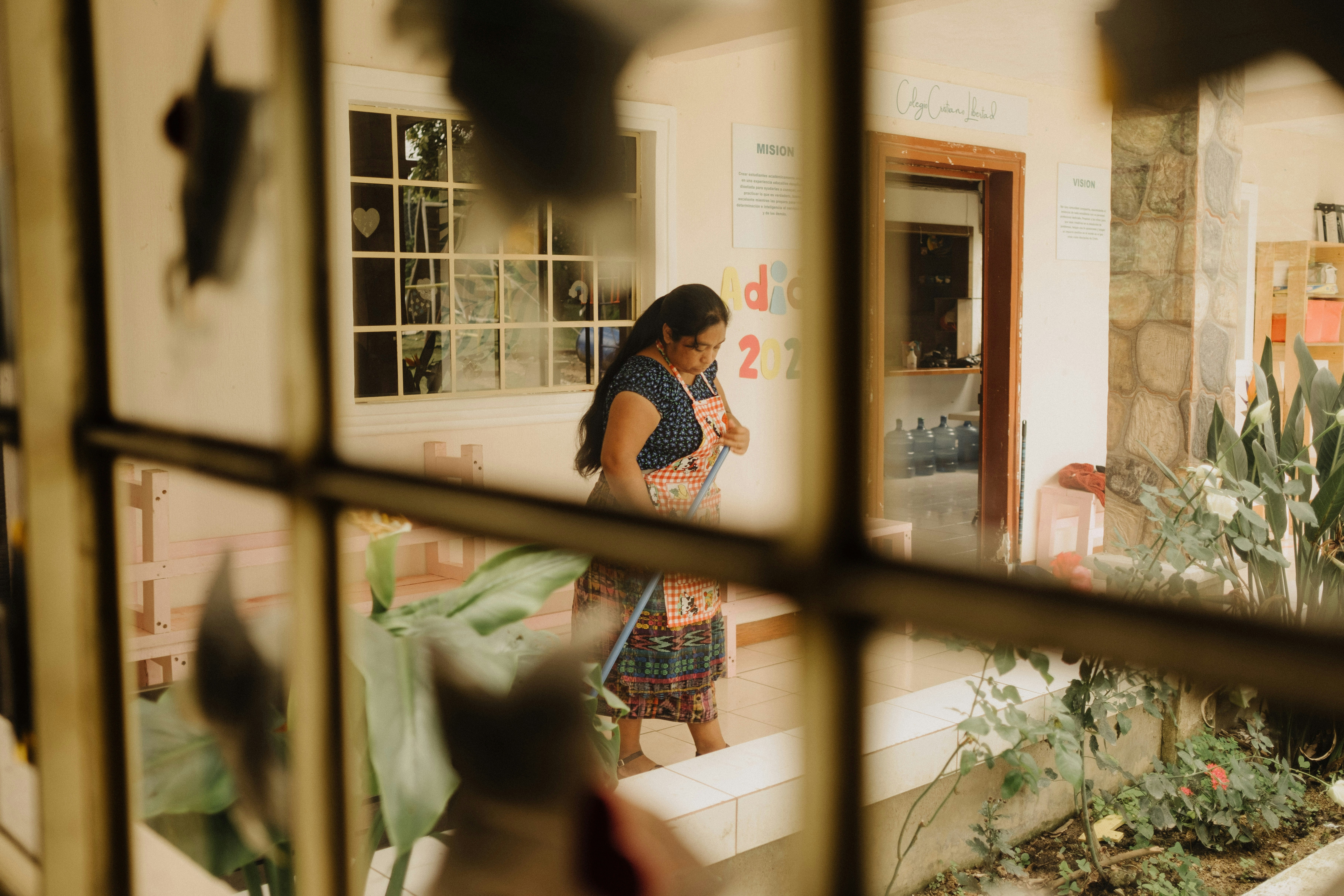 a woman standing in front of a window looking at her cell phone
