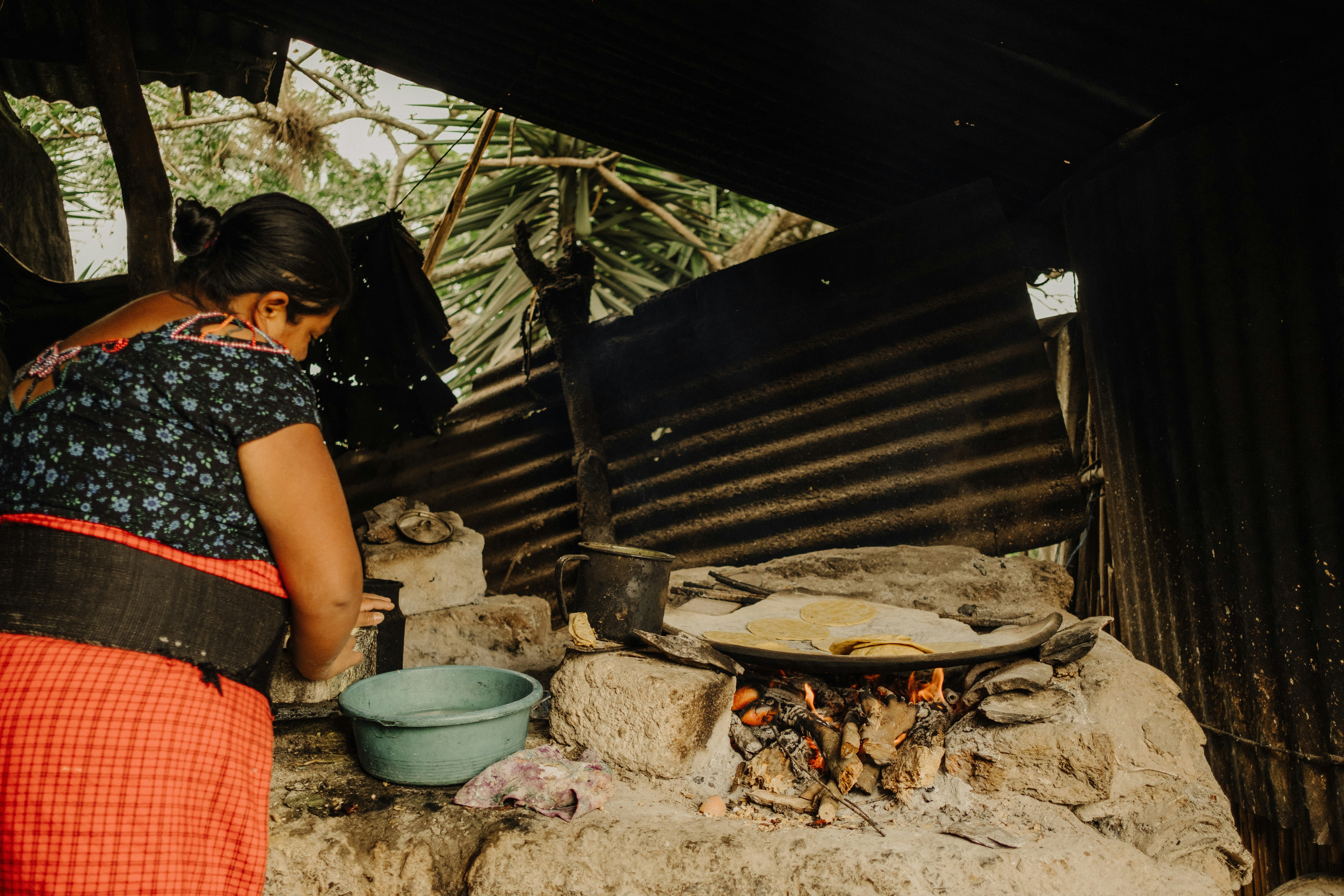 Mujer cocinando sobre fuego abierto